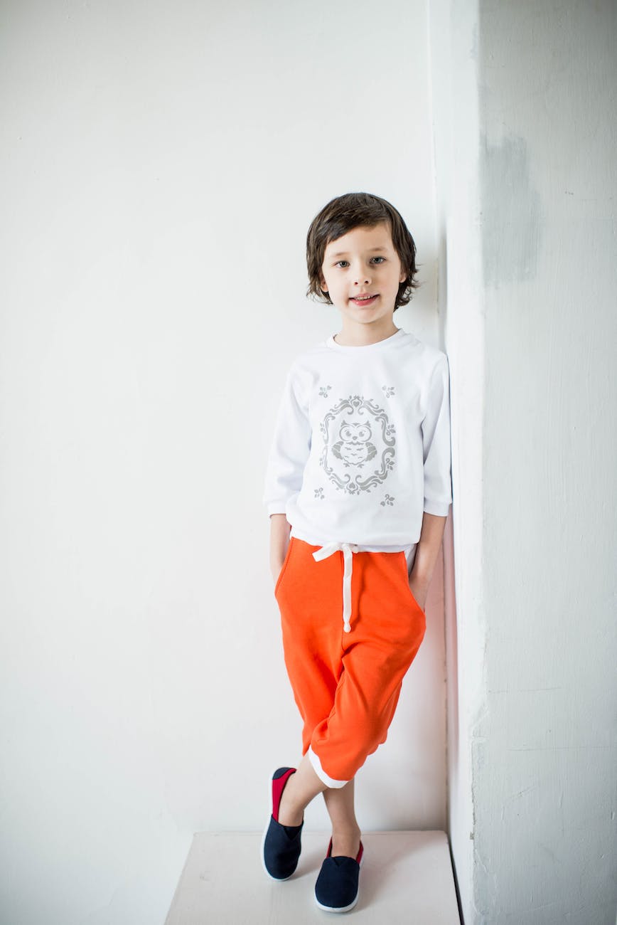 photo of child leaning on wall with feet crossed